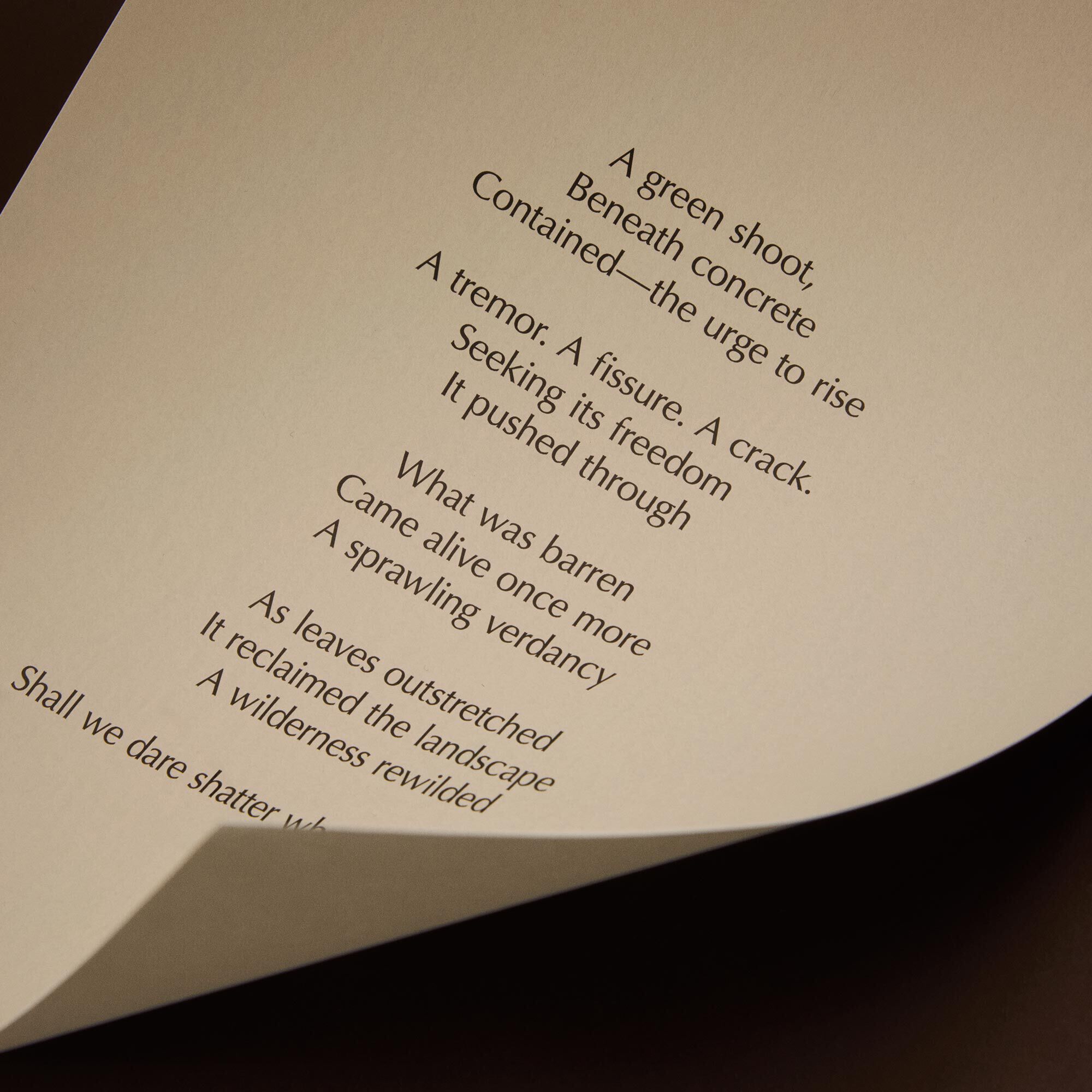 Curved cream page with printed verse against a dark brown background.