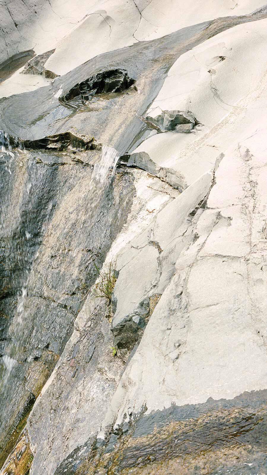 Pale grey granite rock landscape with layered stone formations viewed from above.